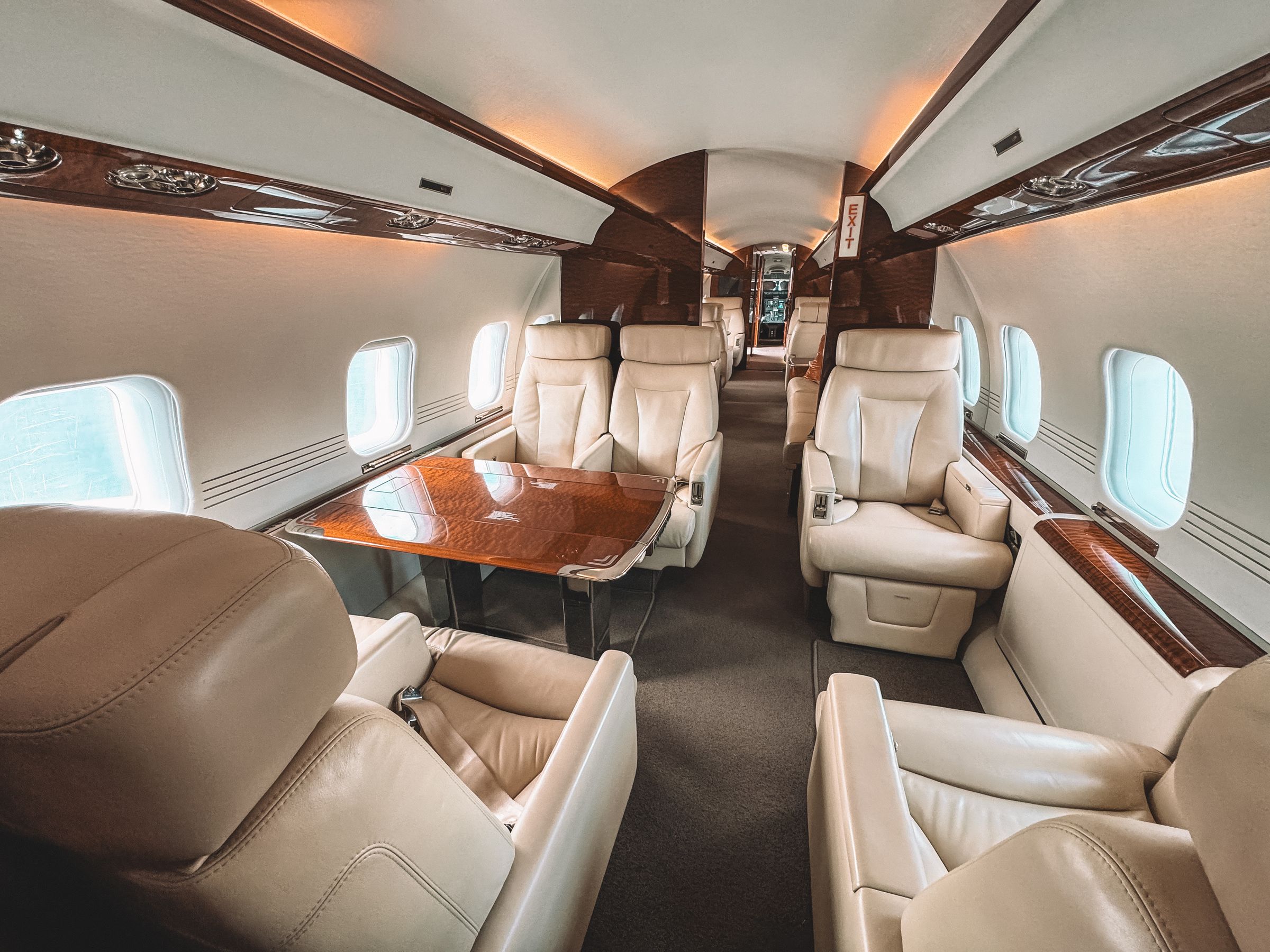 Light-filled business jet cabin with cream leather seating